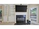 Living room with black marble fireplace, built-in shelving and large window at 910 Renaissance Way, Roswell, GA 30076