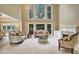 Bright and airy living room featuring tall windows, plush sofas, and a cozy fireplace at 910 Renaissance Way, Roswell, GA 30076