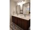 Bright bathroom featuring a double sink vanity with dark wood cabinets and stylish mirrors at 1603 Maston Rd, Auburn, GA 30011