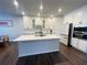 Bright kitchen featuring a central island, modern appliances, white cabinets, and sleek finishes at 1603 Maston Rd, Auburn, GA 30011