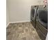 Efficient laundry room with side-by-side washer and dryer units, tiled flooring at 1603 Maston Rd, Auburn, GA 30011