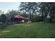 Large backyard with mature trees surrounding a brick home at 3204 Spreading Oak Sw Dr, Atlanta, GA 30311