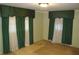 Bedroom with two windows covered in sheer white and dark green curtains at 3204 Spreading Oak Sw Dr, Atlanta, GA 30311