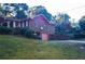 Brick home with a pink garage door and basketball hoop on the side at 3204 Spreading Oak Sw Dr, Atlanta, GA 30311