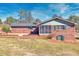 Rear exterior view of a brick home featuring a sunroom and patio at 4031 Pine Needle Dr, Duluth, GA 30096