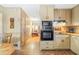 Kitchen view showing cabinets, oven, stovetop, and view into living room at 4031 Pine Needle Dr, Duluth, GA 30096