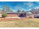 Brick home with screened porch and rear patio featuring a raised brick planter and a mature tree line at 4031 Pine Needle Dr, Duluth, GA 30096