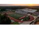 Aerial view of sports field near school featuring a running track, football field, and stadium seating at 606 Goldsmith Ct # 114, Johns Creek, GA 30022