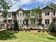 Attractive brick townhome with manicured lawn and professional landscaping under a cloudy blue sky at 606 Goldsmith Ct # 114, Johns Creek, GA 30022