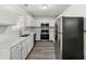 Well-lit kitchen featuring stainless steel appliances, white cabinets, and durable countertops at 6808 Mahonia Pl, Lithonia, GA 30038