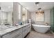 Sleek bathroom with double vanities, a soaking tub, and modern lighting for a spa-like experience at 750 Park Ne Ave # 25W, Atlanta, GA 30326