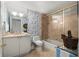 Well-lit bathroom featuring blue floral wallpaper, shower, and a cream vanity with sink at 750 Park Ne Ave # 25W, Atlanta, GA 30326