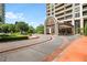 Luxury building entryway featuring a covered drive, circular driveway, and manicured landscaping at 750 Park Ne Ave # 25W, Atlanta, GA 30326