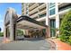Elegant building entrance featuring a porte-cochère, valet service, and meticulous landscaping at 750 Park Ne Ave # 25W, Atlanta, GA 30326