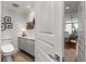 Modern powder room featuring gray cabinets and a peek into a light-filled bedroom at 750 Park Ne Ave # 25W, Atlanta, GA 30326