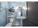 Powder room featuring a pedestal sink, toilet, and shelf in a blue-painted space at 1100 Howell Mill Nw Rd # 708, Atlanta, GA 30318