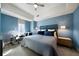 Comfortable bedroom featuring blue walls, plush bedding, a ceiling fan, and a seating area by the window at 1100 Howell Mill Nw Rd # 708, Atlanta, GA 30318
