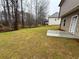 A grassy backyard featuring a bare trees and a concrete pad at 111 Woodside Ct, Temple, GA 30179