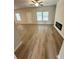 Bright living room featuring wood-look floors, ceiling fan, fireplace and multiple windows at 111 Woodside Ct, Temple, GA 30179