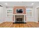 Inviting living room showcasing a stone fireplace, built-in shelving, and hardwood floors at 130 Staddlebridge Ave, Canton, GA 30114