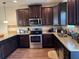 Kitchen features granite countertops, dark wood cabinetry, and stainless steel appliances, all illuminated by modern lighting at 2190 Bridgewater Pass, Hampton, GA 30228