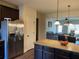 A kitchen featuring granite countertops, a stainless steel refrigerator and an island with a view of the living room at 2190 Bridgewater Pass, Hampton, GA 30228