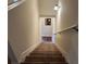 Carpeted stairway leading to upper level, featuring neutral-toned walls, decorative lighting and white trim at 2190 Bridgewater Pass, Hampton, GA 30228