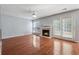 Cozy living room with hardwood floors, fireplace, ceiling fan, and double doors at 4030 Brushy Creek Way, Suwanee, GA 30024