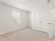 Inviting bedroom with neutral carpet, a window, and a closet with white bi-fold doors at 4167 Viola Pl, Atlanta, GA 30349