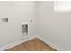 Laundry room with hardwood floor, utility hookups, and wire shelving at 4167 Viola Pl, Atlanta, GA 30349