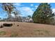 Large backyard of white home with black roof, complete with firepit and wooded perimeter at 5382 Whitaker Nw Trl, Acworth, GA 30101