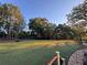 Large grassy backyard with mature trees and a stone patio at 5382 Whitaker Nw Trl, Acworth, GA 30101