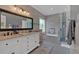 Modern bathroom featuring double vanities, a soaking tub, and a glass-enclosed shower with decorative tile at 5382 Whitaker Nw Trl, Acworth, GA 30101
