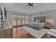 Serene bedroom with tray ceiling, large windows, and a plush upholstered bed frame on hardwood floors at 5382 Whitaker Nw Trl, Acworth, GA 30101