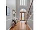 Charming foyer with hardwood floors, staircase, and inviting decor including a bench, wreath, and stylish rug at 5382 Whitaker Nw Trl, Acworth, GA 30101