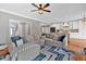 Open-concept living room and kitchen featuring hardwood floors, stainless steel appliances and modern ceiling fan at 5382 Whitaker Nw Trl, Acworth, GA 30101