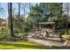 Backyard fire pit area featuring a stone patio and comfortable seating surrounded by mature trees at 2212 Austin Lake Se Dr, Smyrna, GA 30082