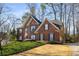 Beautiful brick home with blue shutters, manicured lawn, and mature trees against a clear blue sky at 2212 Austin Lake Se Dr, Smyrna, GA 30082