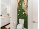 Modern half bathroom with a toilet and a decorative green floral panel at 238 Olympic Pl, Decatur, GA 30030