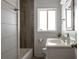 Cozy bathroom with a shower-tub combo, wooden accent wall, and natural light at 2886 Salmon Se Ave, Atlanta, GA 30317