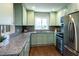 Modern kitchen with light green cabinets, stainless steel appliances, and gray backsplash at 2886 Salmon Se Ave, Atlanta, GA 30317