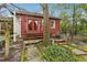 Cozy outdoor patio with red shingle siding, charming red door, and mature shade trees at 698 Bellemeade Nw Ave, Atlanta, GA 30318