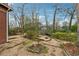 Stone and gravel backyard with lush foliage and firepit area at 698 Bellemeade Nw Ave, Atlanta, GA 30318