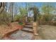 Stone stairs with brick accents leading to a landscaped backyard and metal fencing at 698 Bellemeade Nw Ave, Atlanta, GA 30318