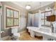 Bathroom with hardwood floors, a clawfoot bathtub, pedestal sink, and shuttered windows at 698 Bellemeade Nw Ave, Atlanta, GA 30318