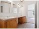 Bathroom features a double vanity and tiled floors, with natural light from an adjacent room at 95 Riverbrooke Trl, Covington, GA 30016