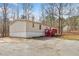 Exterior shot with red stairs and neutral siding, featuring a side yard surrounded by mature trees at 95 Riverbrooke Trl, Covington, GA 30016