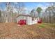 Side view of the house with white siding, red shutters, and a well-manicured lawn at 95 Riverbrooke Trl, Covington, GA 30016