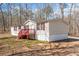 Charming house with white siding, red shutters and deck, and mature trees in the yard at 95 Riverbrooke Trl, Covington, GA 30016