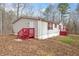 Front view of the home with neutral siding, red shutters, and a red deck with stairs at 95 Riverbrooke Trl, Covington, GA 30016